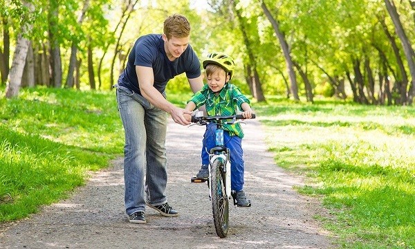 montar a un niño en una bicicleta de dos ruedas